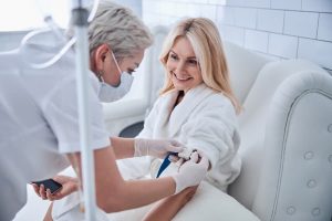 Seated patient prepping to receive infusion therapy