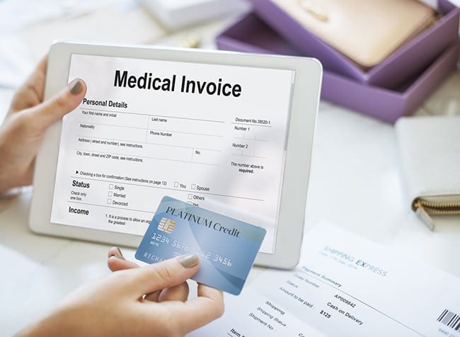 Woman making medical payment on tablet with credit card