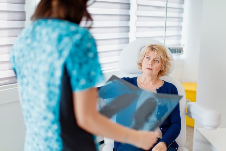 Seated patient talking with provider who is holding scan of lungs