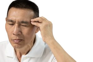 Patient with headache places hand on head