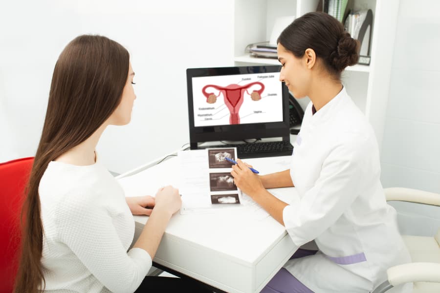 Doctor showing ultrasound of her ovaries to woman