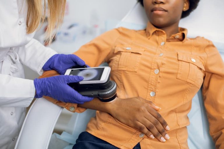 An oncologist checks a patient for skin cancer