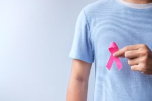 Man holding up a pink ribbon for breast cancer awareness