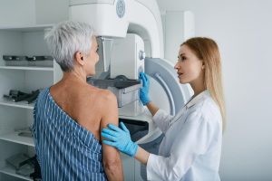 Healthcare provider instructing patient during mammogram screening