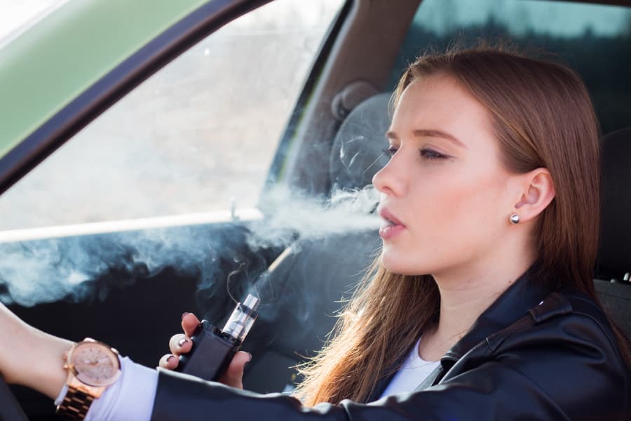 Woman vaping while driving car