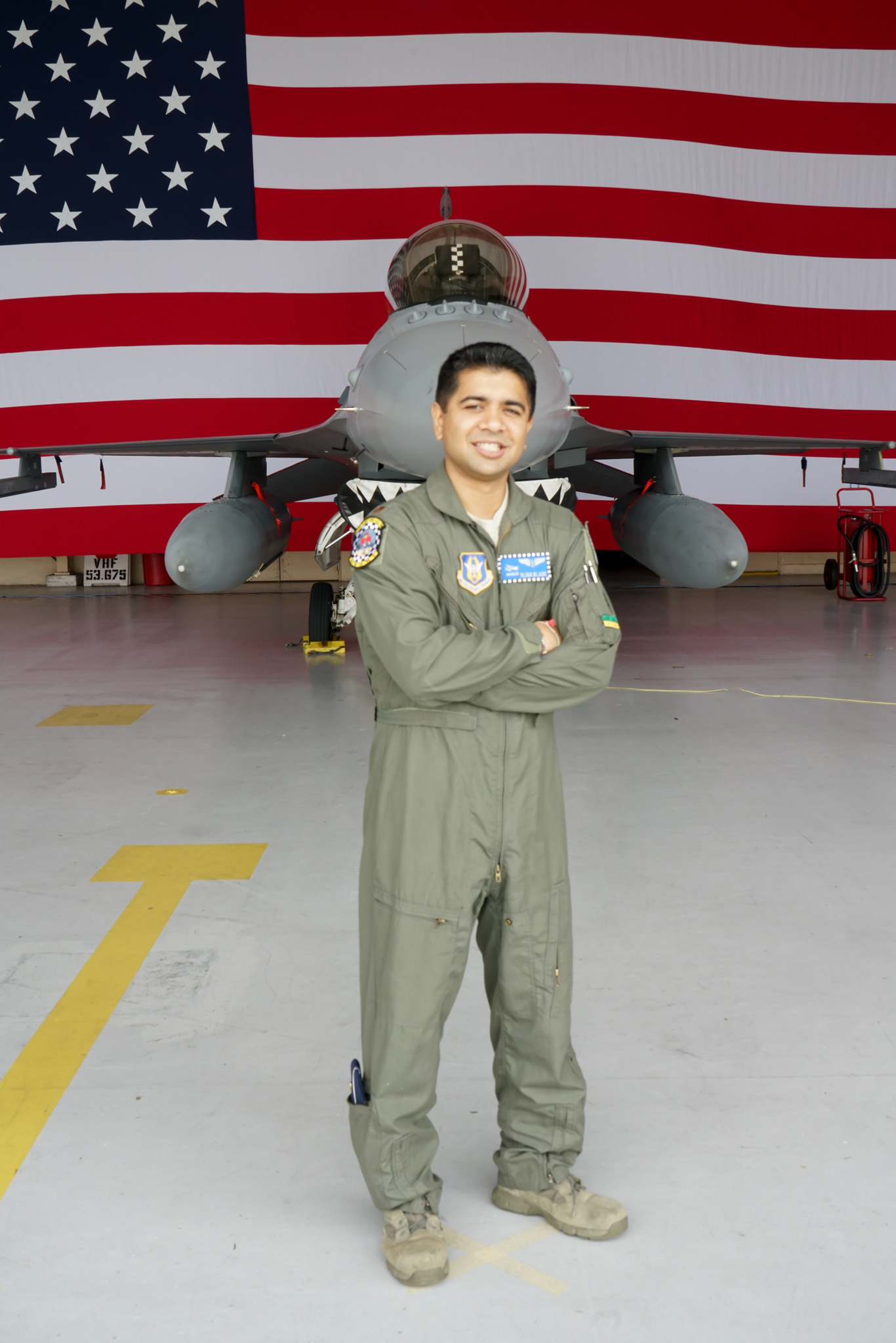 Dr. Avishek Kumar, RCCA oncologist, poses in flight suit with an Air Force Reserve jet.