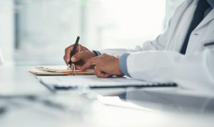 Doctor writing medical biopsy report
