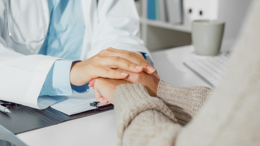 doctor holding hands with a Myelodysplastic Syndromes patient.