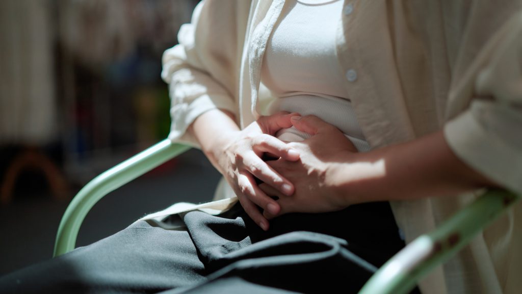 Woman feeling abdominal pain from ovarian cancer