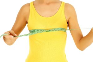 Young person using tape to measure breasts