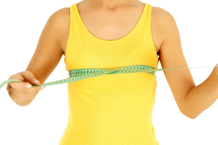 Young person using tape to measure breasts