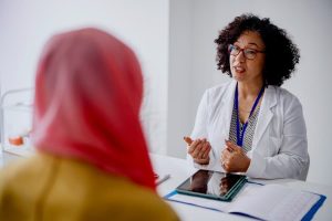 Gynecologist speaking with patient in office setting
