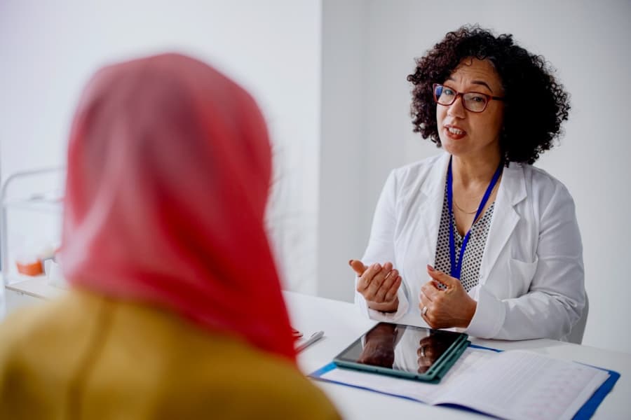 Gynecologist speaking with patient in office setting