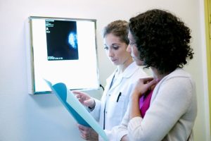 Cancer care team looking at files in front of X-ray