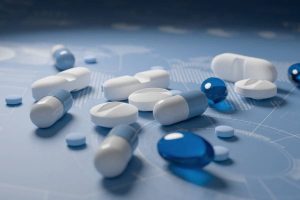 Pile of various pills on blue background