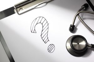 Stethoscope on clipboard with drawn question mark