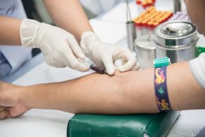 Phlebotomist drawing blood from patient’s arm