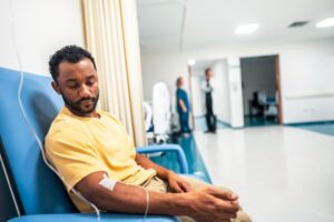 Patient sitting in chair in hospital getting infusion in arm