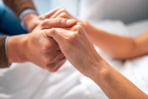 Older person and younger person holding hands