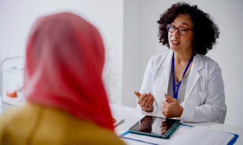 Gynecologist speaking with patient in office setting