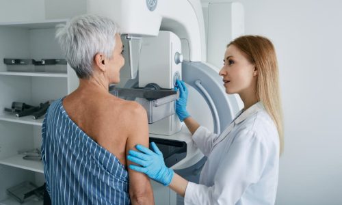 Healthcare provider instructing patient during mammogram screening