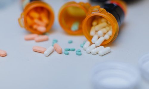 Open pill bottles spilling onto counter