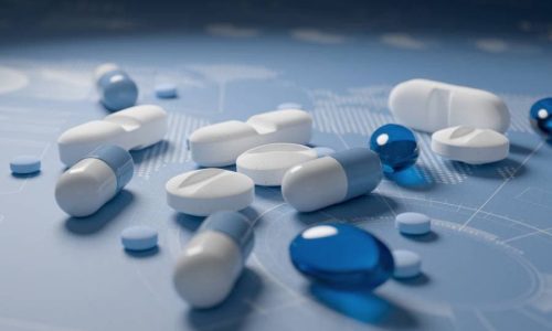 Pile of various pills on blue background